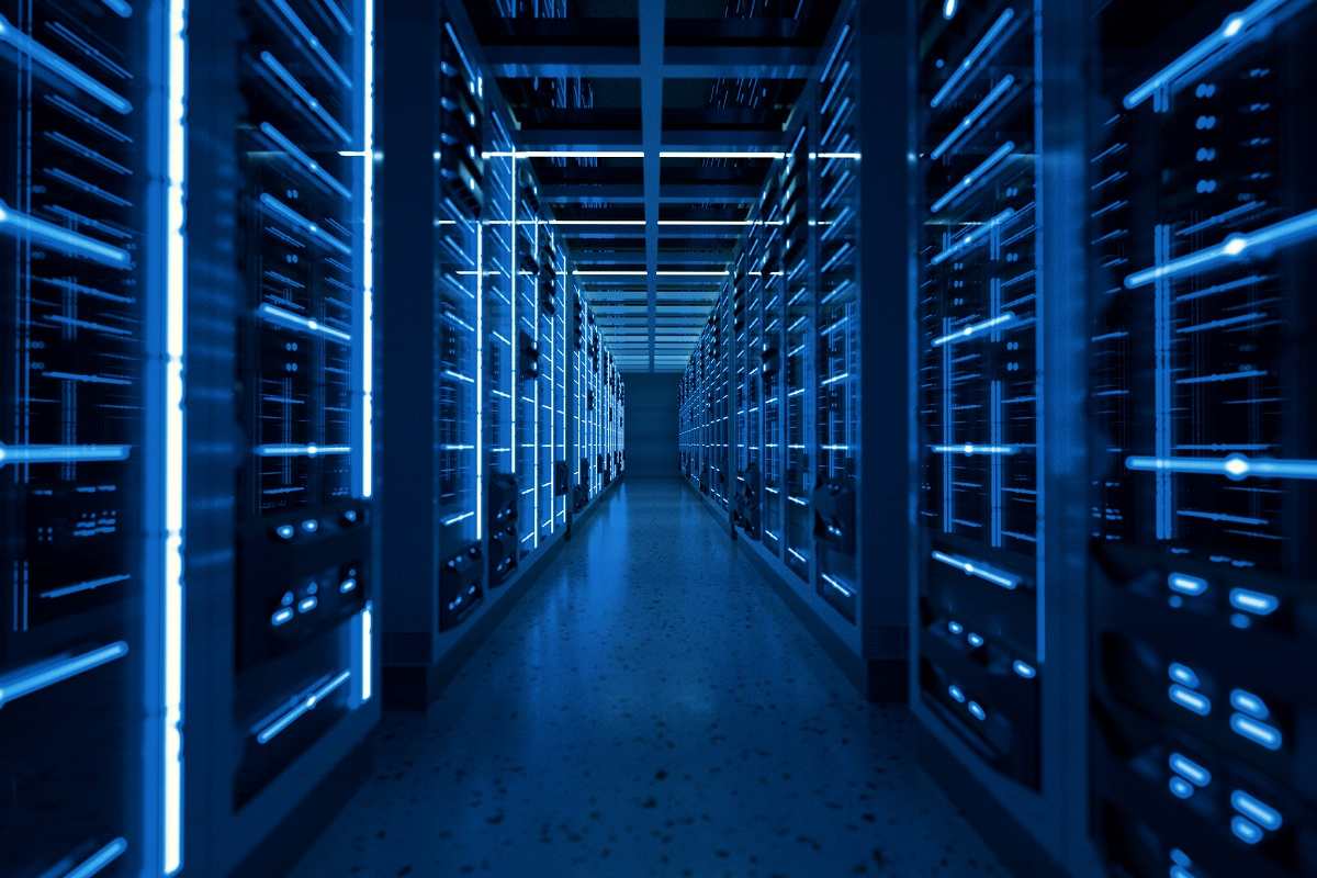 A server room with several servers illuminated by a dull, blue light.